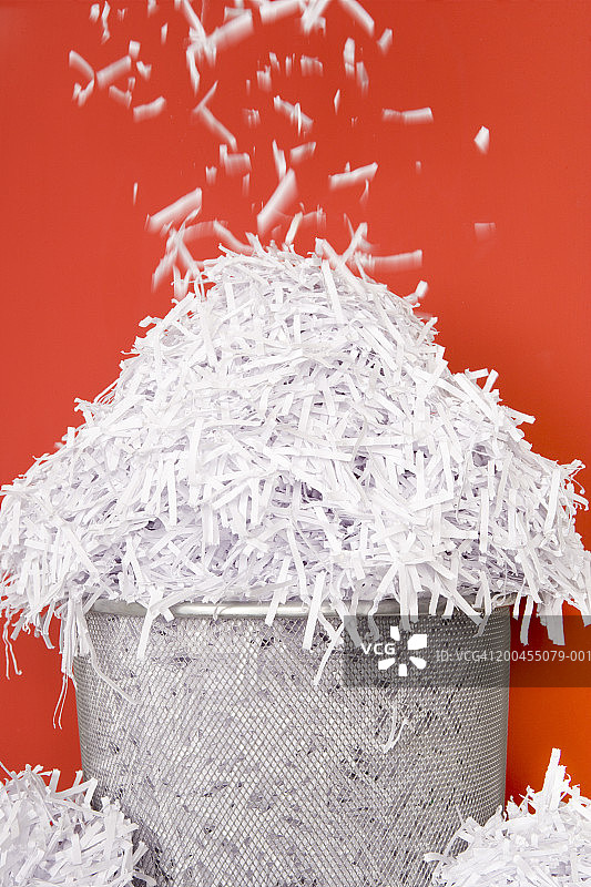 纸屑落入满溢的废纸篓特写图片素材