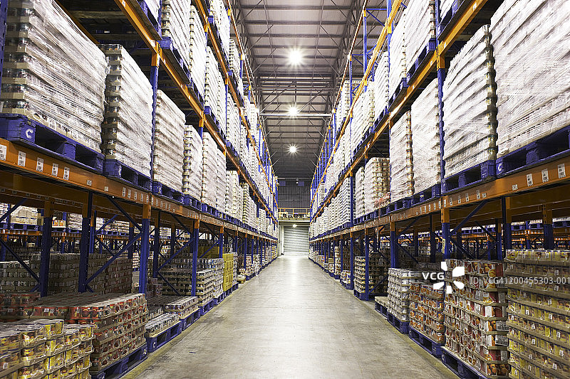 仓库过道中堆放在托盘上的农产品罐头图片素材
