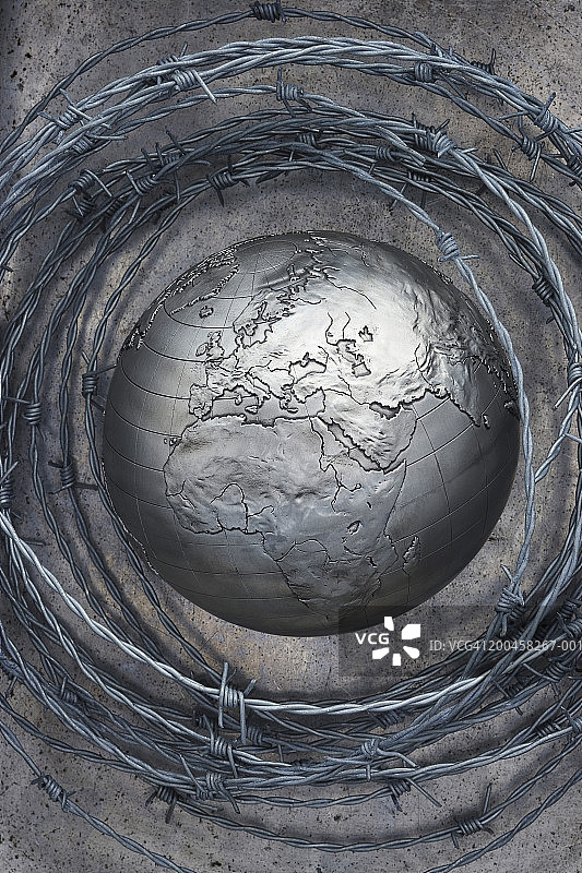 带刺铁丝环绕的金属地球仪，展示非洲和欧洲图片素材