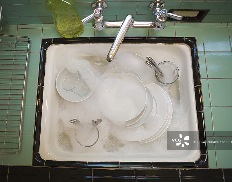 水槽中带有水和泡沫的餐具图片素材