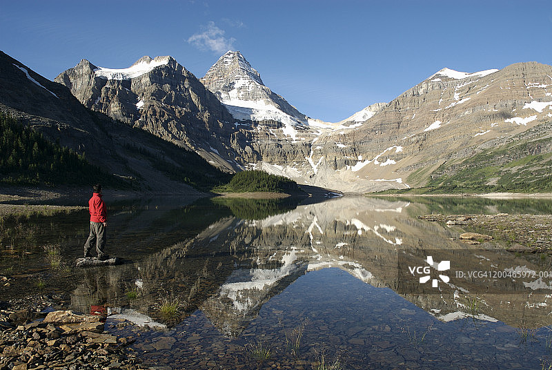 男人站在湖中的岩石上图片素材