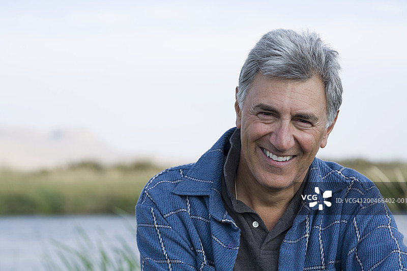 在河边微笑的年长男人肖像图片素材