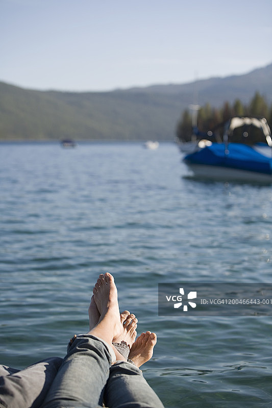 年轻男人和女人坐在码头上，低角度拍摄图片素材