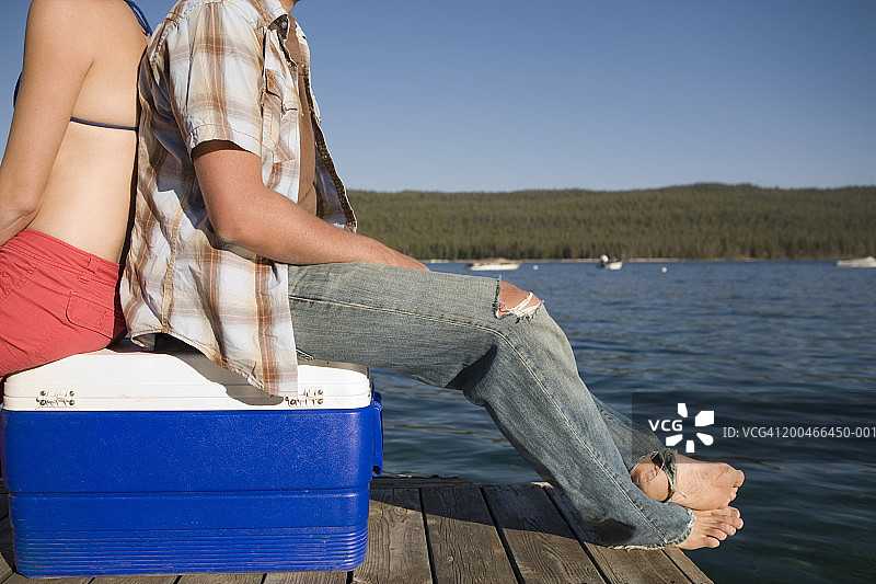 坐在码头冷藏箱上的年轻男女图片素材