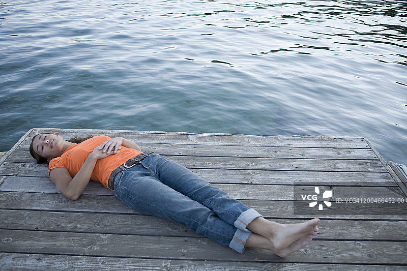年轻女人躺在码头上图片素材