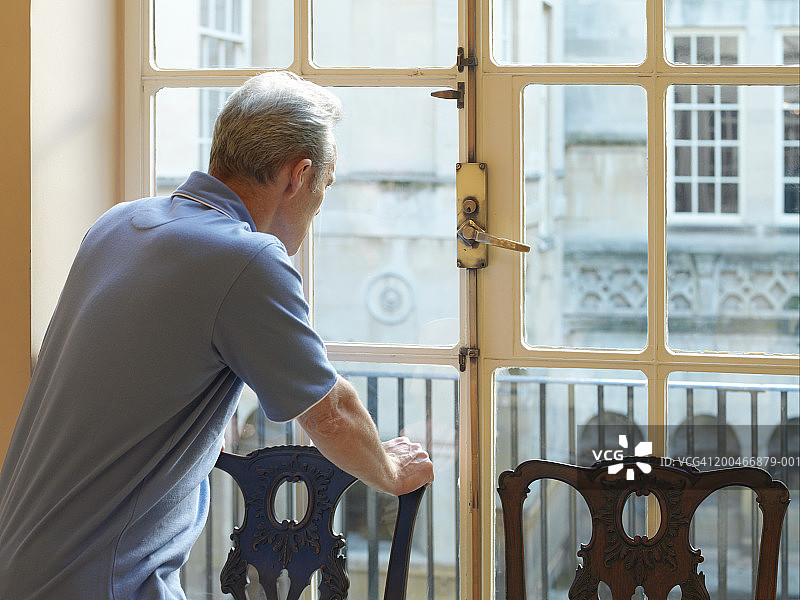 靠在椅子背上，望向窗外的中年男人图片素材