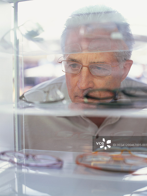 正在看眼镜的中年男人图片素材