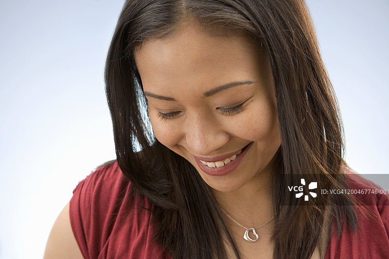 年轻女人微笑，向下看图片素材
