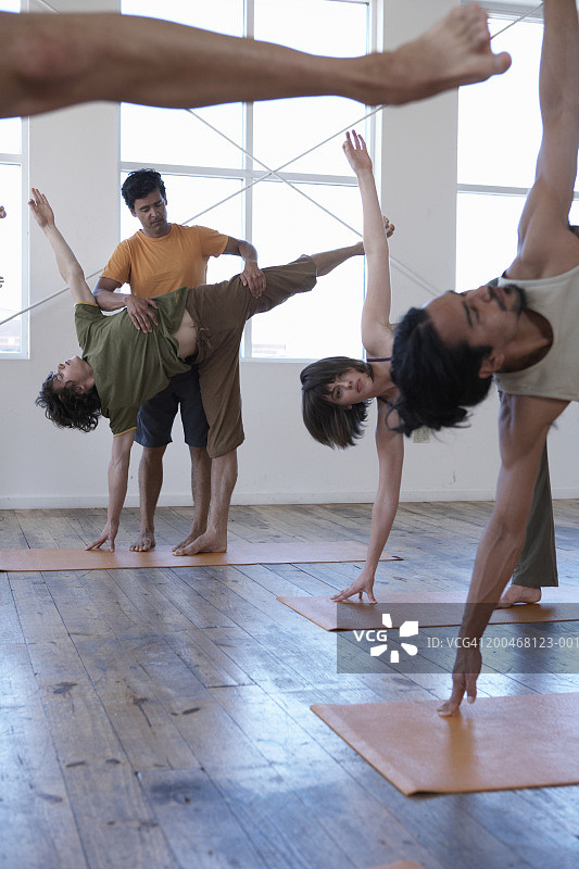 男性瑜伽教练指导成人学生上瑜伽课图片素材