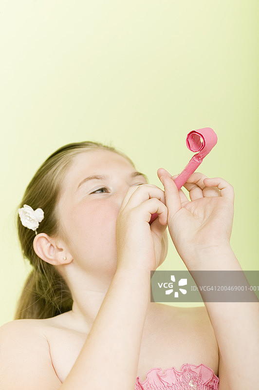9-11岁女孩吹派对喇叭图片素材