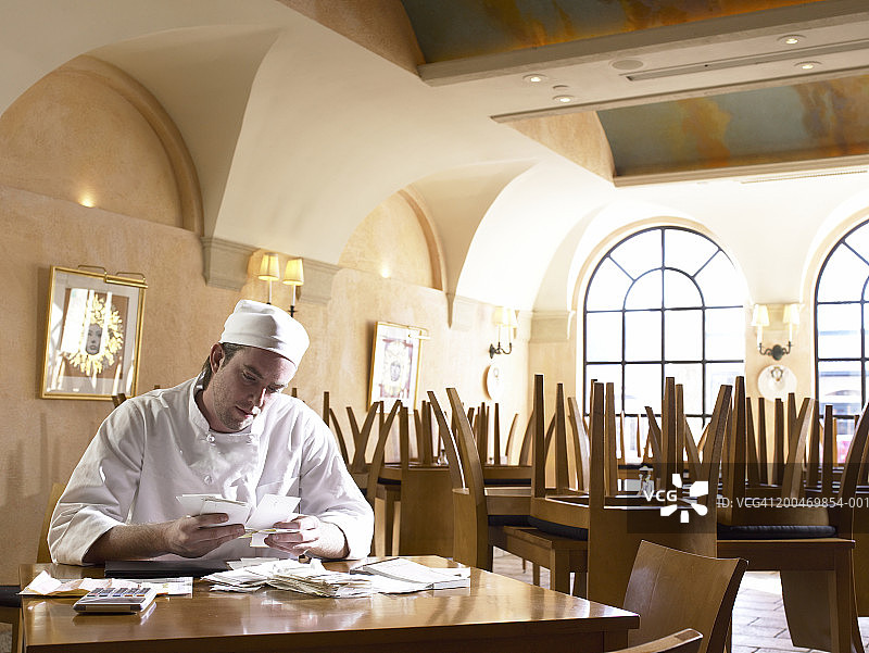 厨师在关门的餐厅里查看收据图片素材