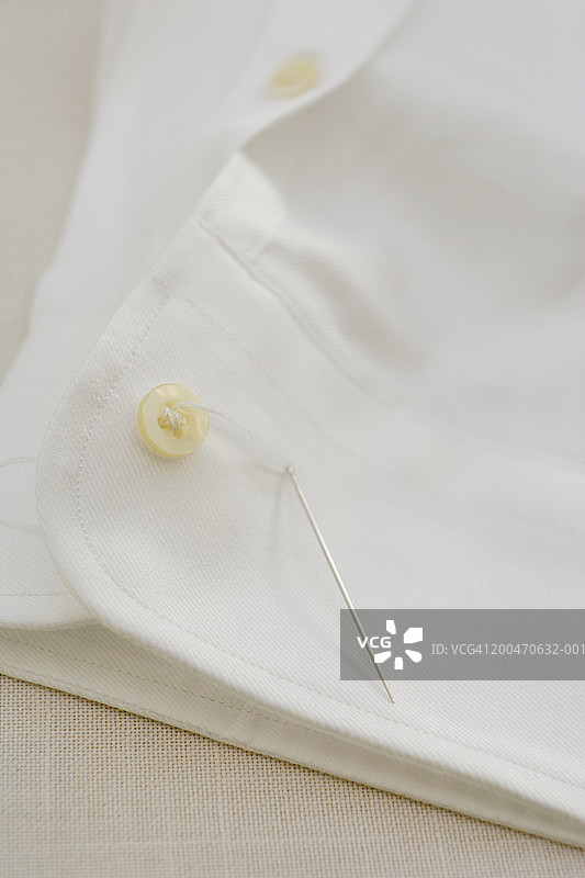 白色衬衫袖口上的缝纫纽扣图片素材