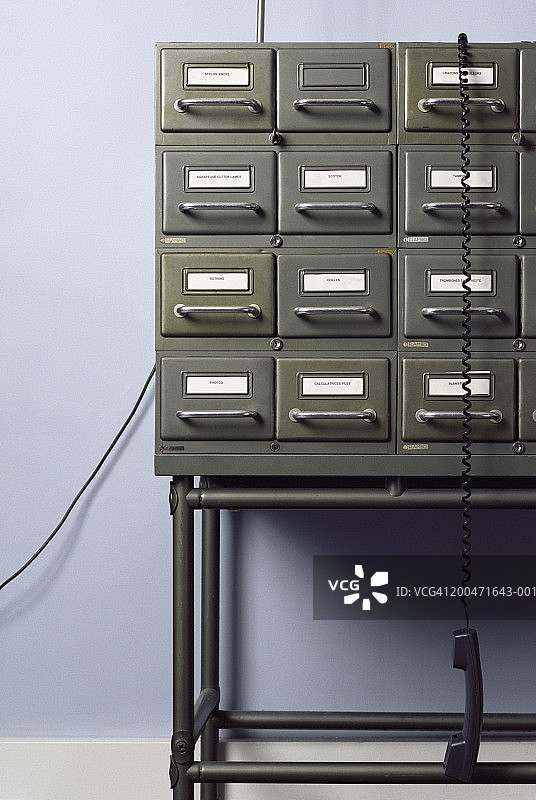 悬挂在文件柜上的电话听筒图片素材