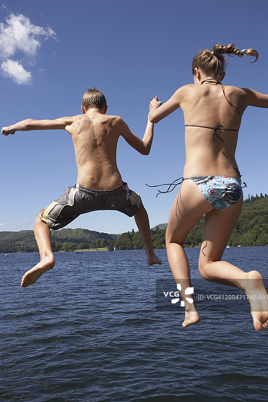 青少年男女（12-14岁）跳入湖中，后视图图片素材