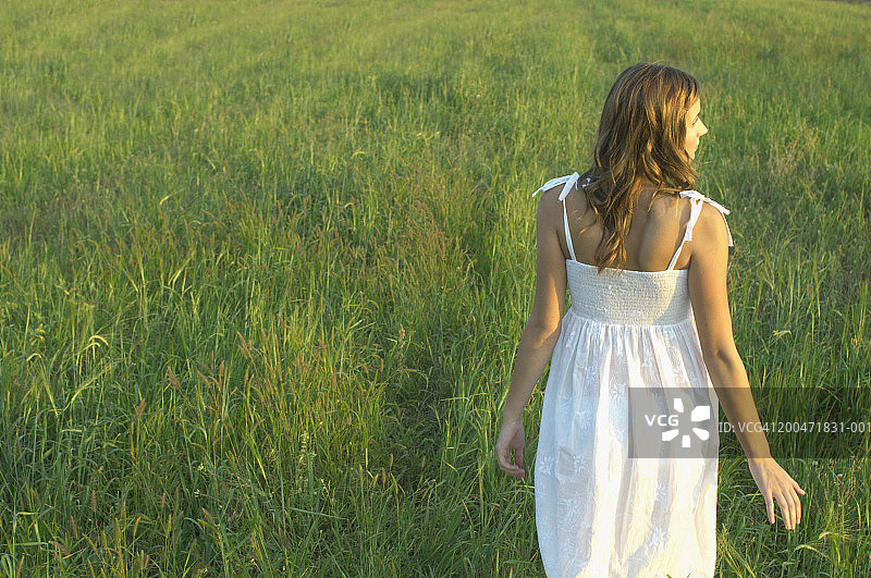 穿过长草地的少女背影（16-18岁）图片素材
