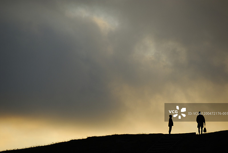 黄昏时分，站在地平线上的人的剪影图片素材