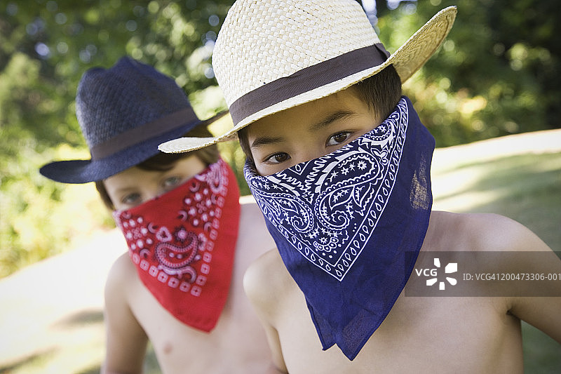 两个男孩（7-9岁）戴着牛仔帽和手帕图片素材