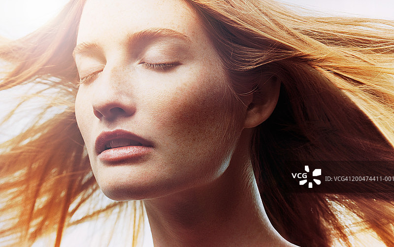 头发在风中飞舞，闭着眼睛的年轻女人特写图片素材