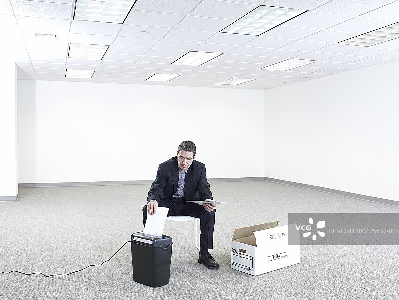 商人在空旷的办公室里撕毁文件图片素材