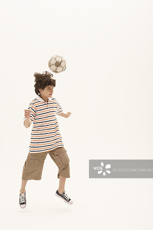 用头顶足球的10-12岁男孩（动态模糊）图片素材