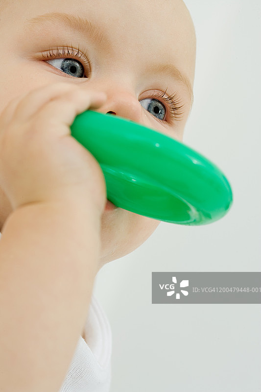 正在咬磨牙环的9-12个月大的宝宝特写图片素材