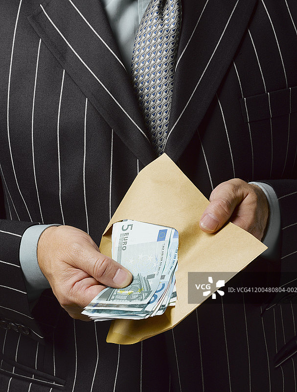 商人拿着一包欧元纸币，特写，中间部分图片素材