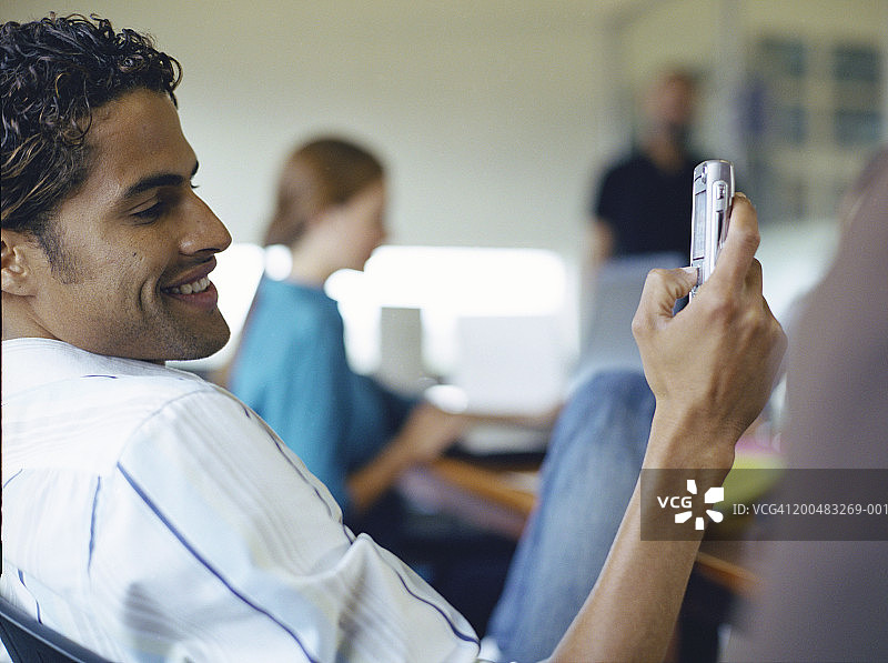 在办公室使用手机的男人，特写镜头图片素材