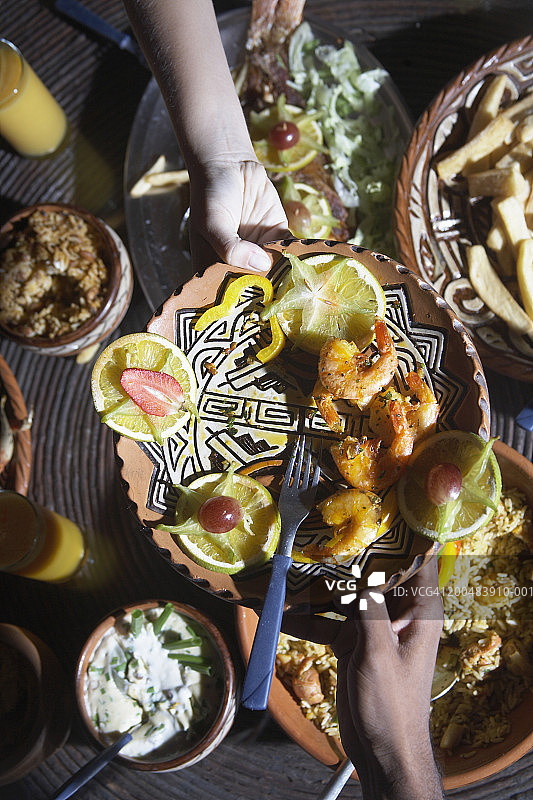 人们传递烤虾拼盘（特写，仰视）图片素材