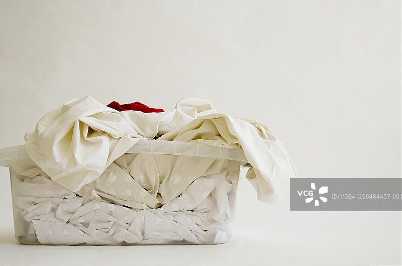 一篮子白色衣物，顶部有一件红色衣物图片素材