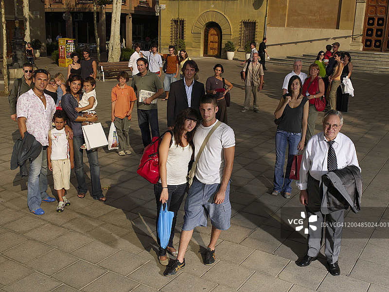站在广场上微笑合影的人群图片素材