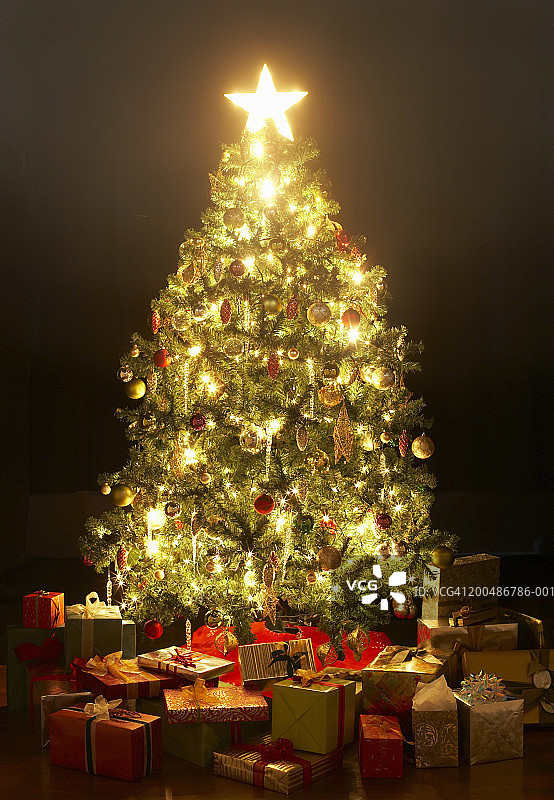 点亮星星的圣诞树周围的礼物图片素材