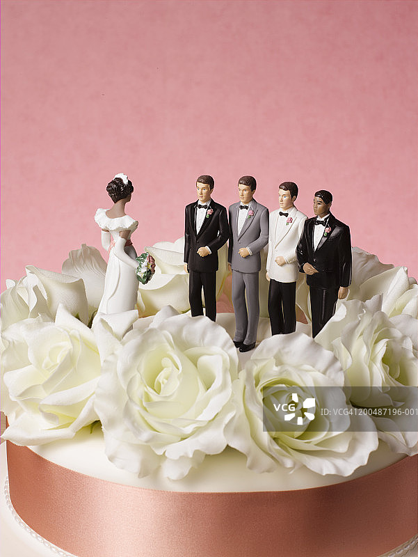 婚礼蛋糕上的新娘人偶与四个新郎选择图片素材