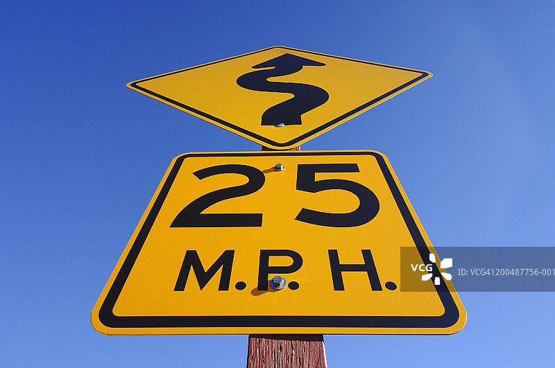 限速25英里的黄色标志和箭头标志，低角度视图图片素材