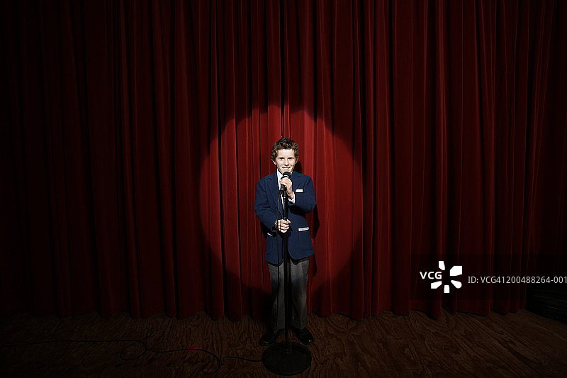 舞台上拿着麦克风的男孩（11-13岁）图片素材