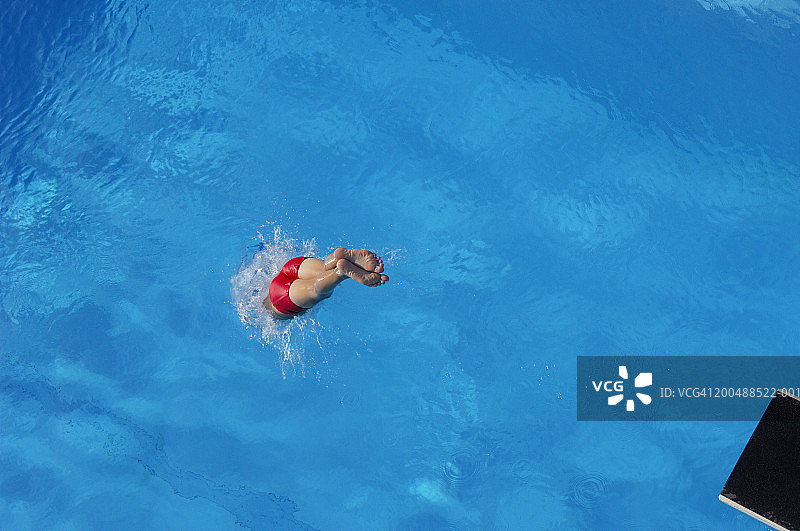 男孩跳入游泳池，后视图图片素材