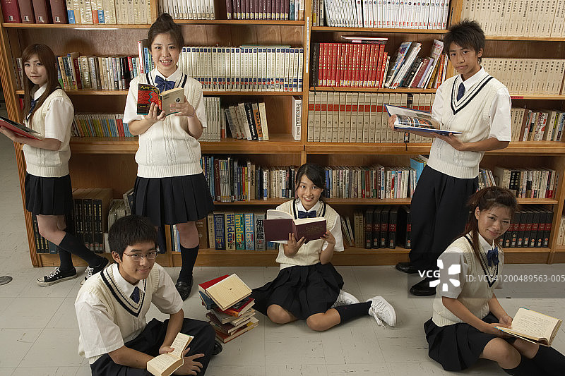 青少年和成年学生在图书馆里看书图片素材