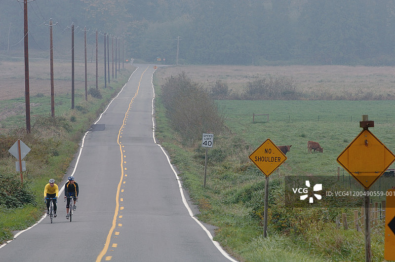 美国华盛顿州康乃馨镇两个男人在秋天骑自行车图片素材