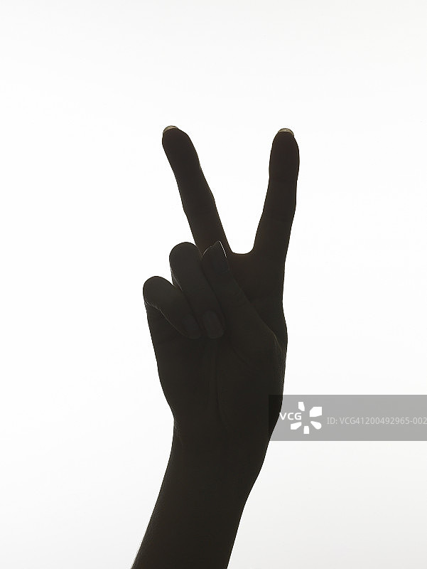 做“和平”手势的女人剪影，特写镜头图片素材