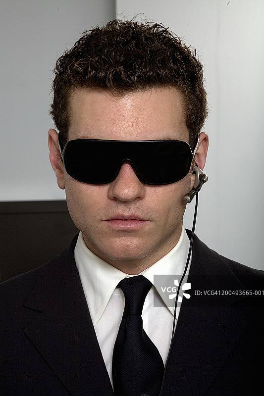 戴着墨镜和免提手机设备的商人图片素材