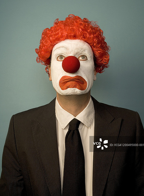 打扮成小丑的商人，面带悲伤，正面肖像图片素材