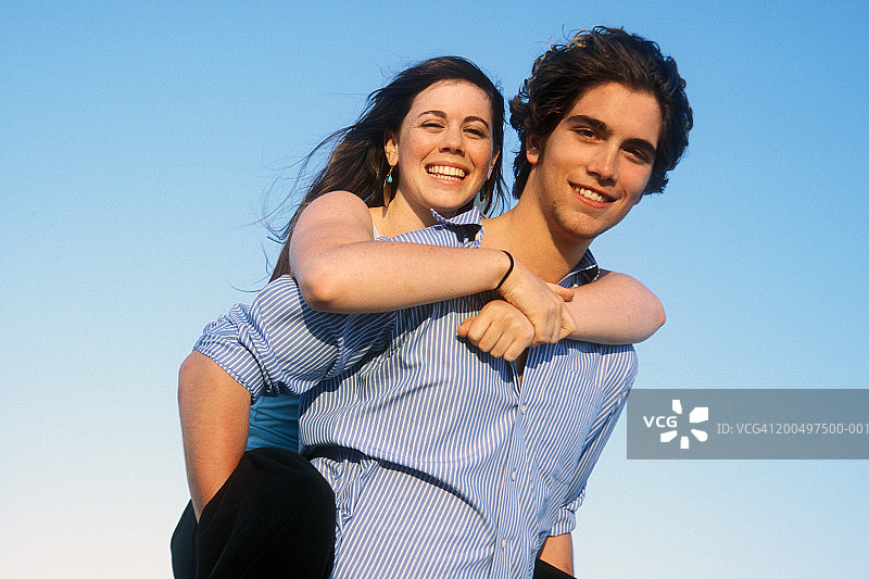 青少年男孩（16-18岁）背着女孩的肖像图片素材
