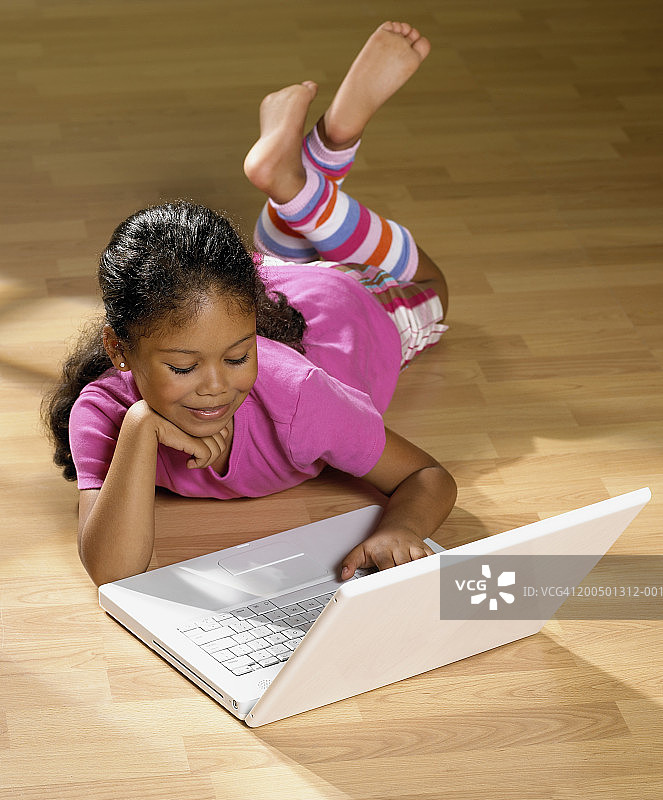 躺在地板上使用笔记本电脑的女孩（4-6岁）图片素材