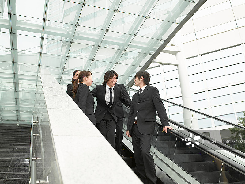 四位高管乘坐自动扶梯（低角度）图片素材
