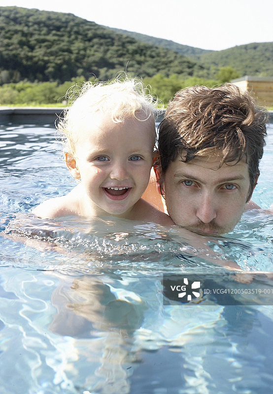 父子（2-4岁）在泳池里游泳图片素材