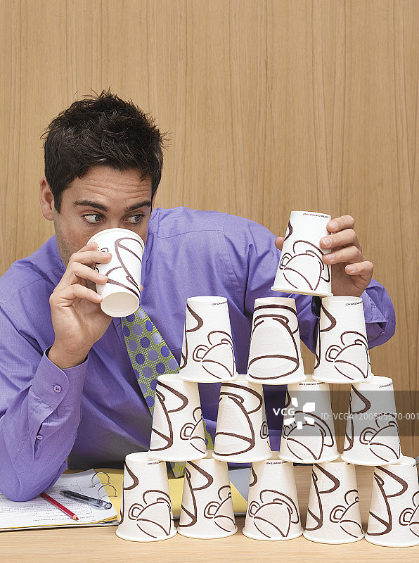 男人用咖啡杯建造塔图片素材