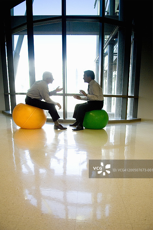 两位坐在健身球上的中年商人侧视图图片素材