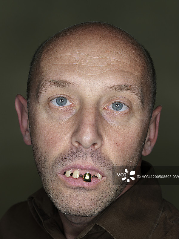 中年男人戴着假牙，做着鬼脸，特写肖像图片素材