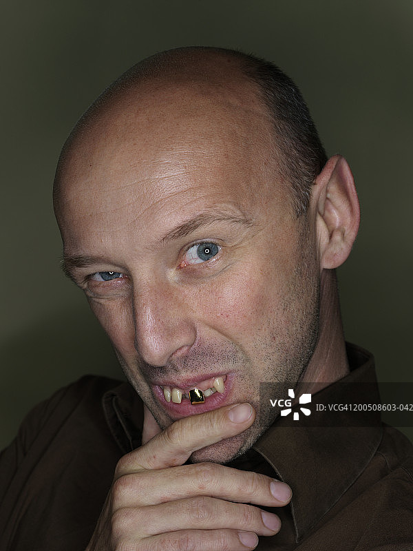 中年男人戴着假牙，做着鬼脸，特写肖像图片素材