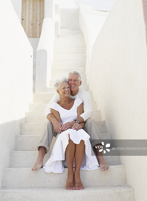 希腊伊亚，坐在台阶上的中年夫妇图片素材