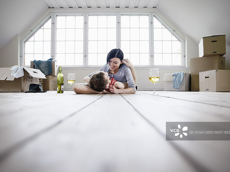 在新家地板上拥抱的年轻夫妇图片素材